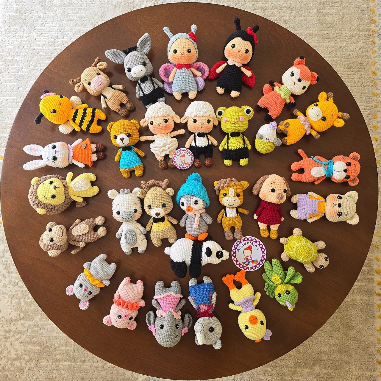 Dozens of tiny crocheted animal figures arranged on a round table