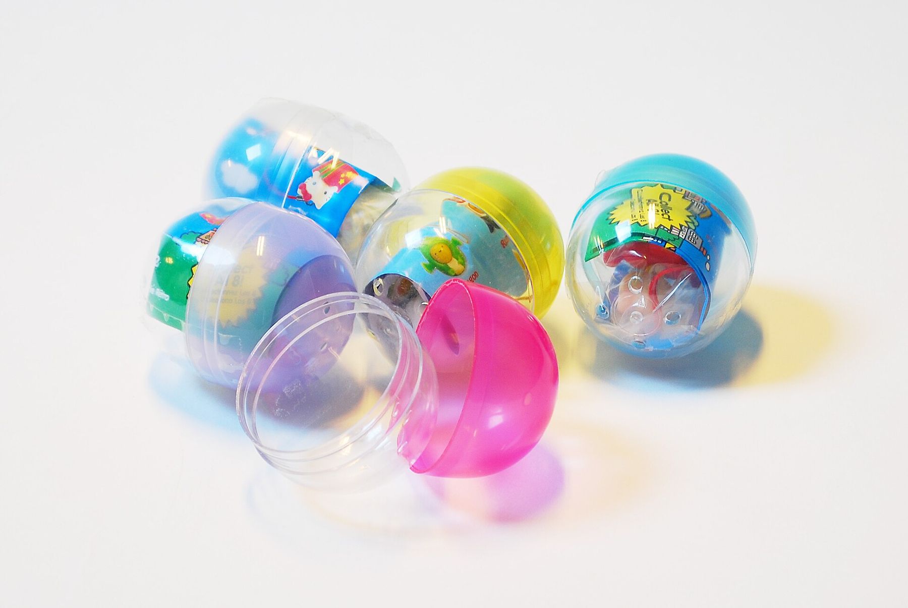 Clear and pastel capsule toy balls on a white table