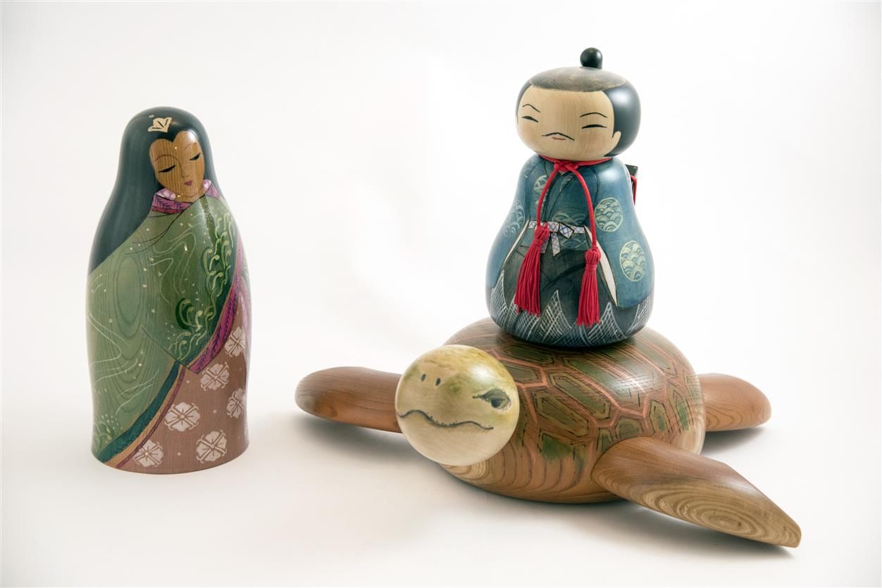 Small painted figurines riding a wooden turtle