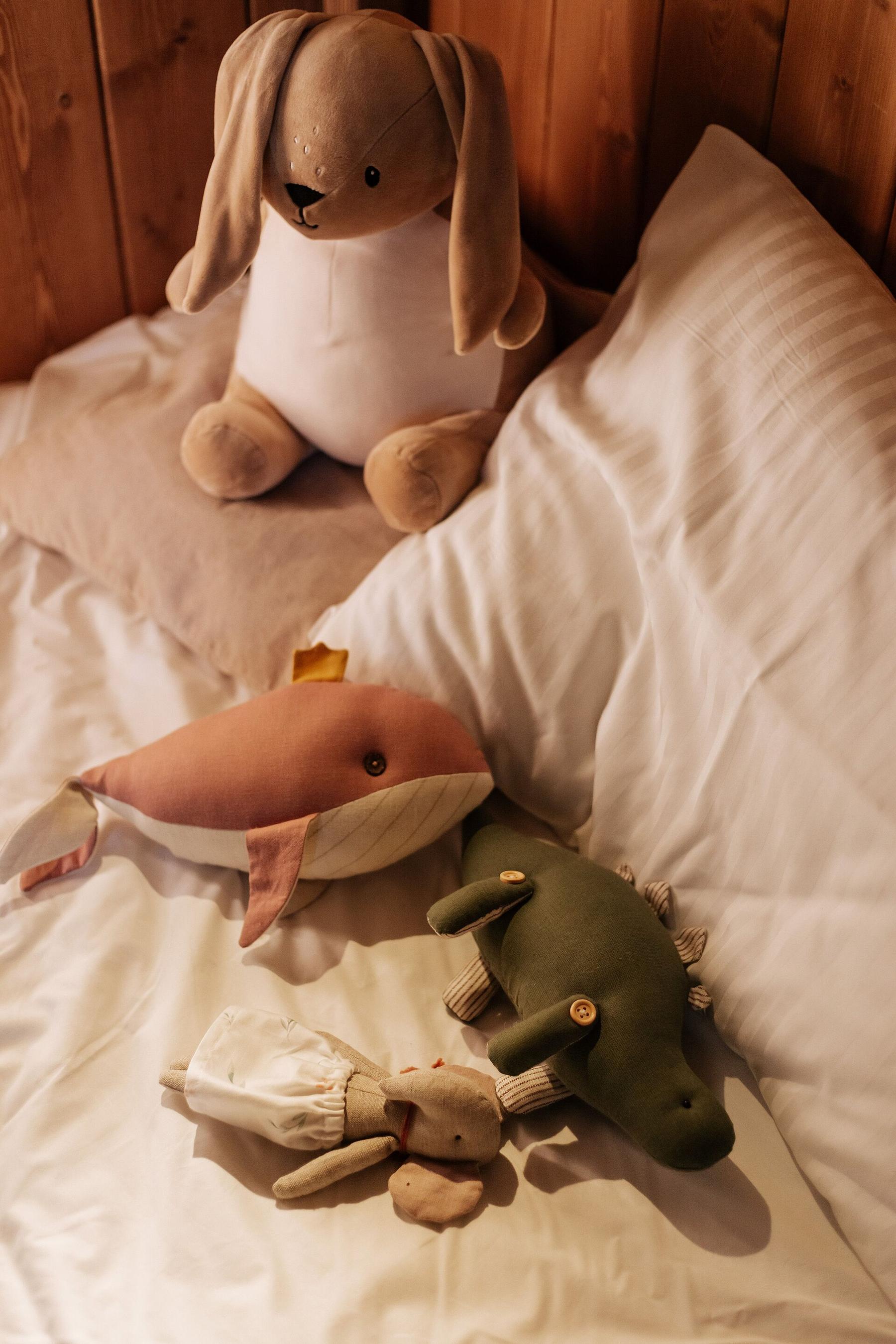 A well-loved plush bunny resting on a pillow in bed