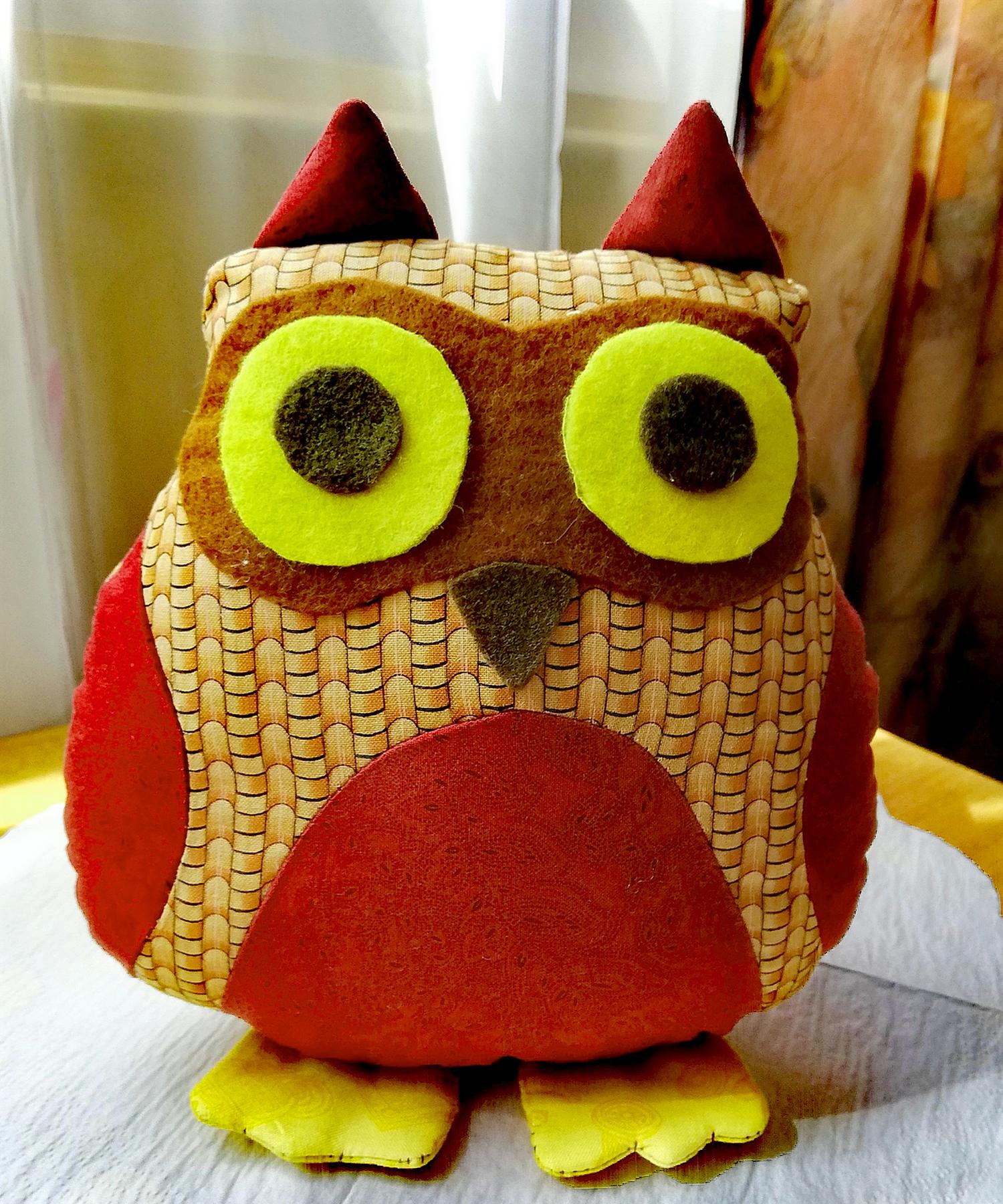 A handmade fabric owl plush with big yellow eyes