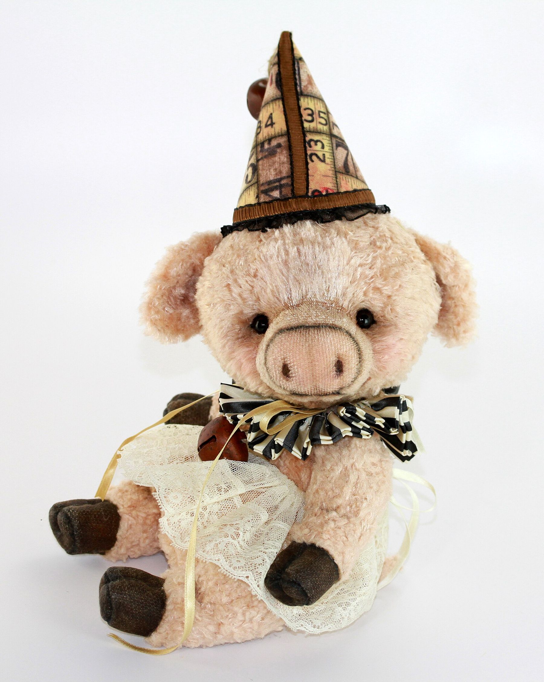 A plush pig wearing a party hat and ruffled collar