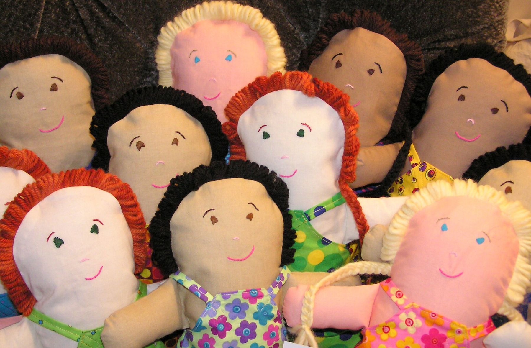 A group of handmade rag dolls with yarn hair