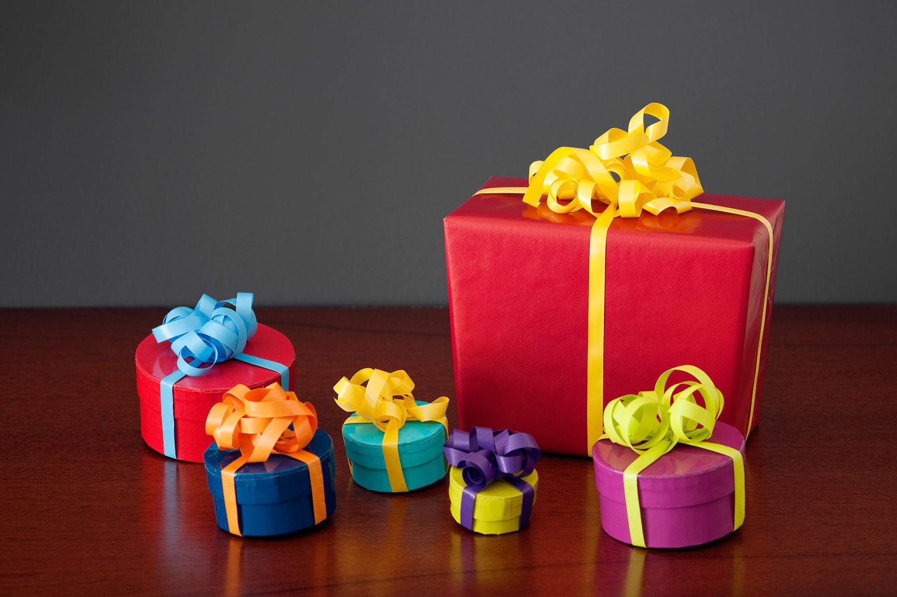 A big red present and small gifts with curly ribbons