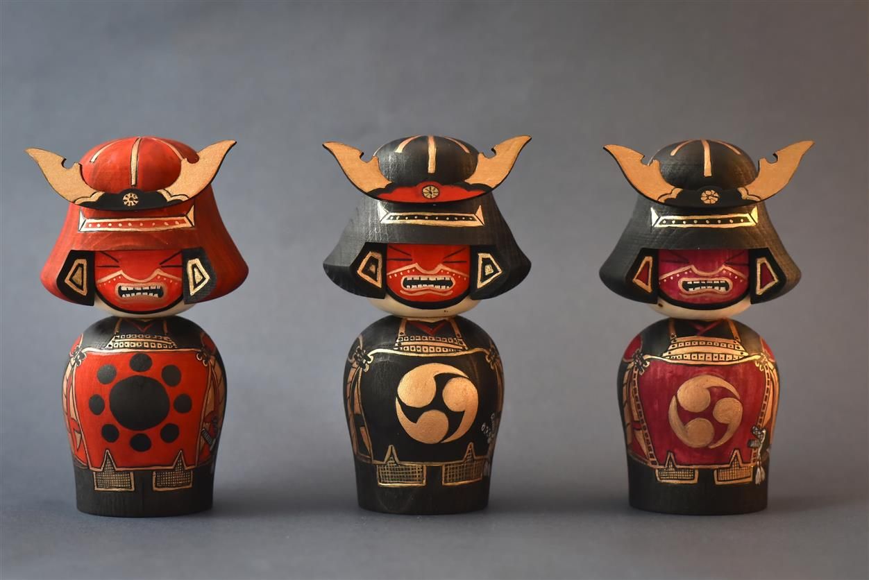Three matching red and black collectible figurines displayed in a row