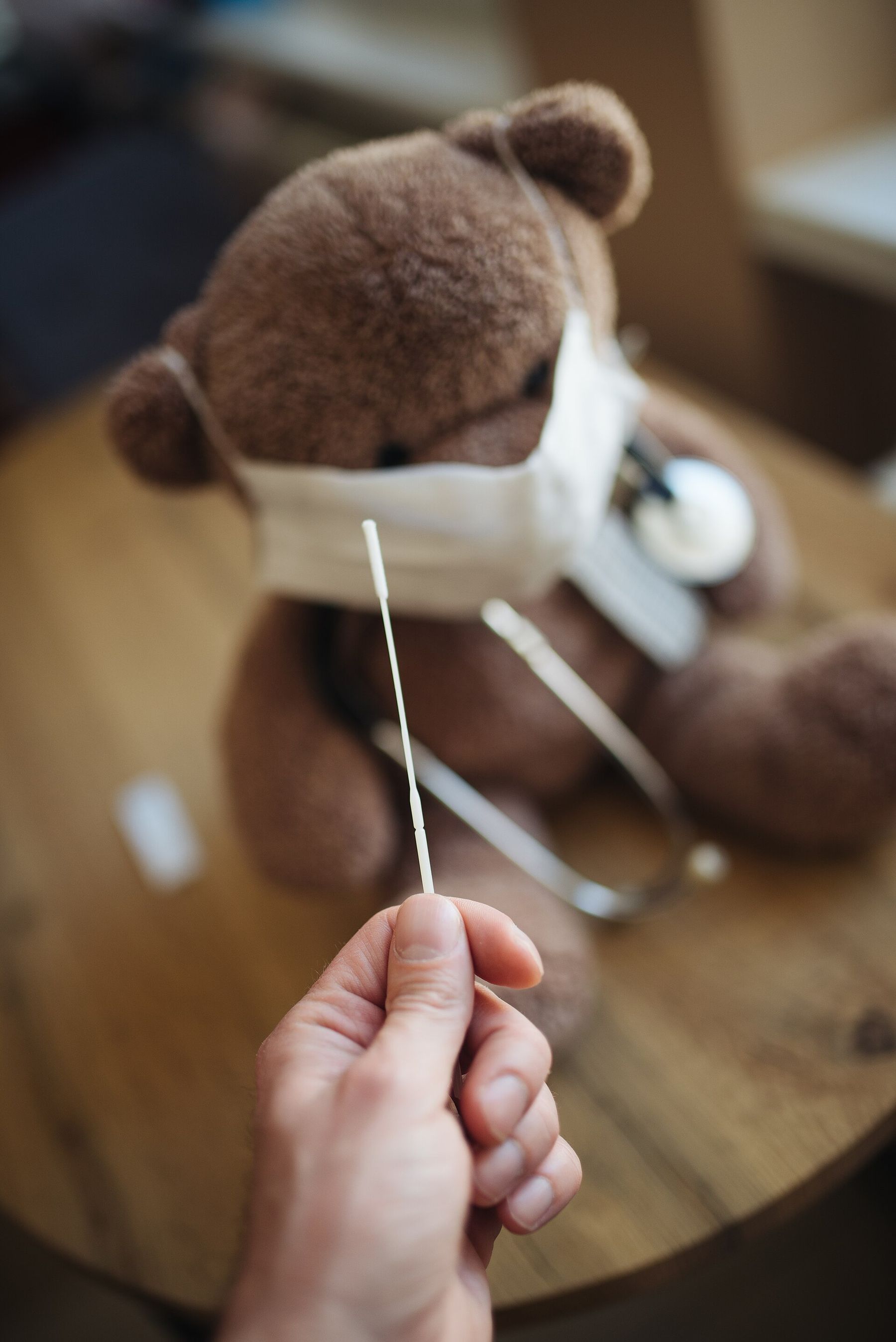 A teddy bear in a face mask getting a gentle check-up