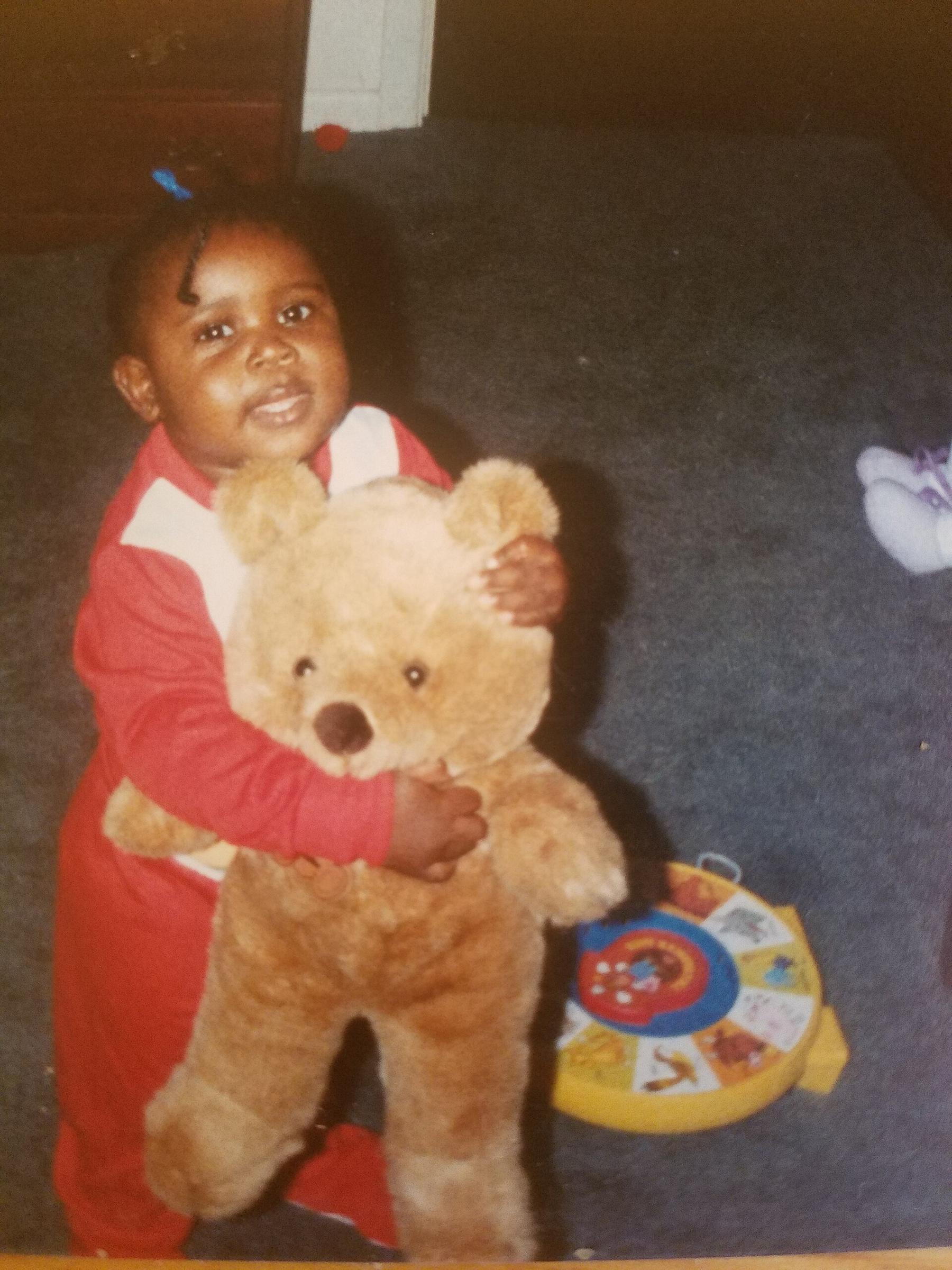 A toddler hugging a big teddy bear